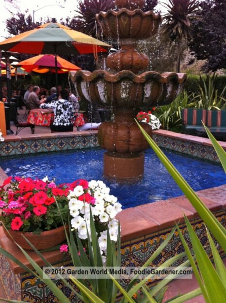 Outdoor dining patio at Casa de Bandini with fountain and blue pool